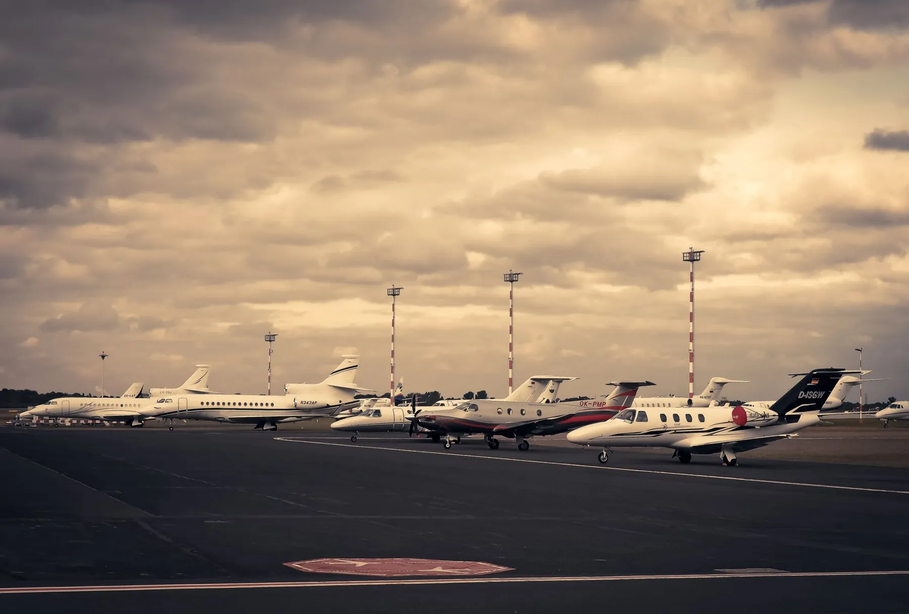 Business jets parked on an airport ramp at dusk